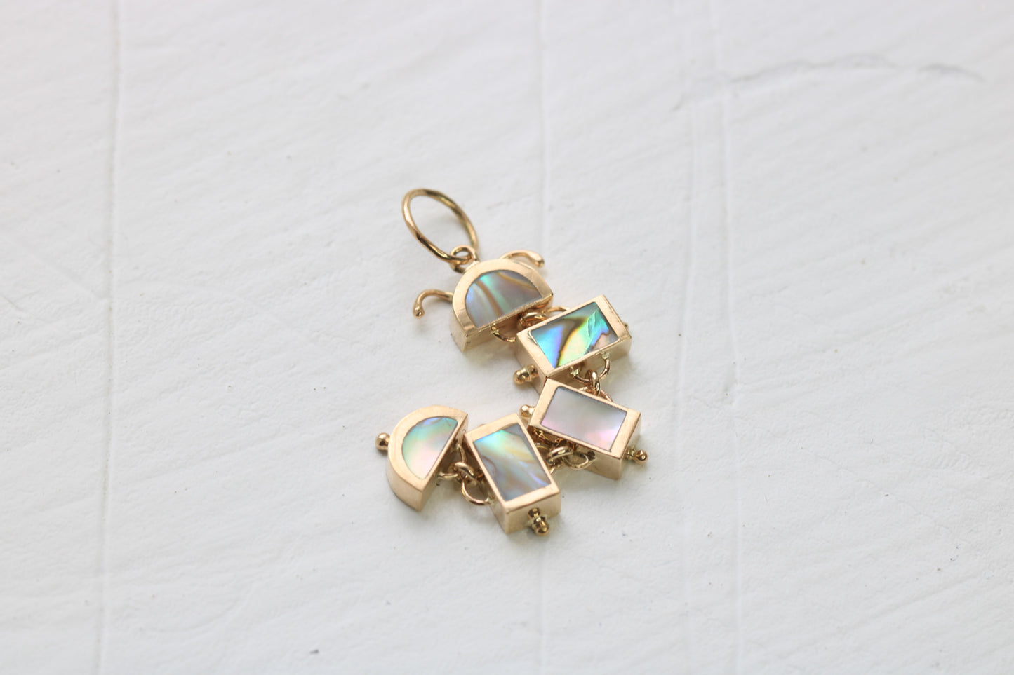 14k gold caterpillar in five pieces of inlaid abalone on white background