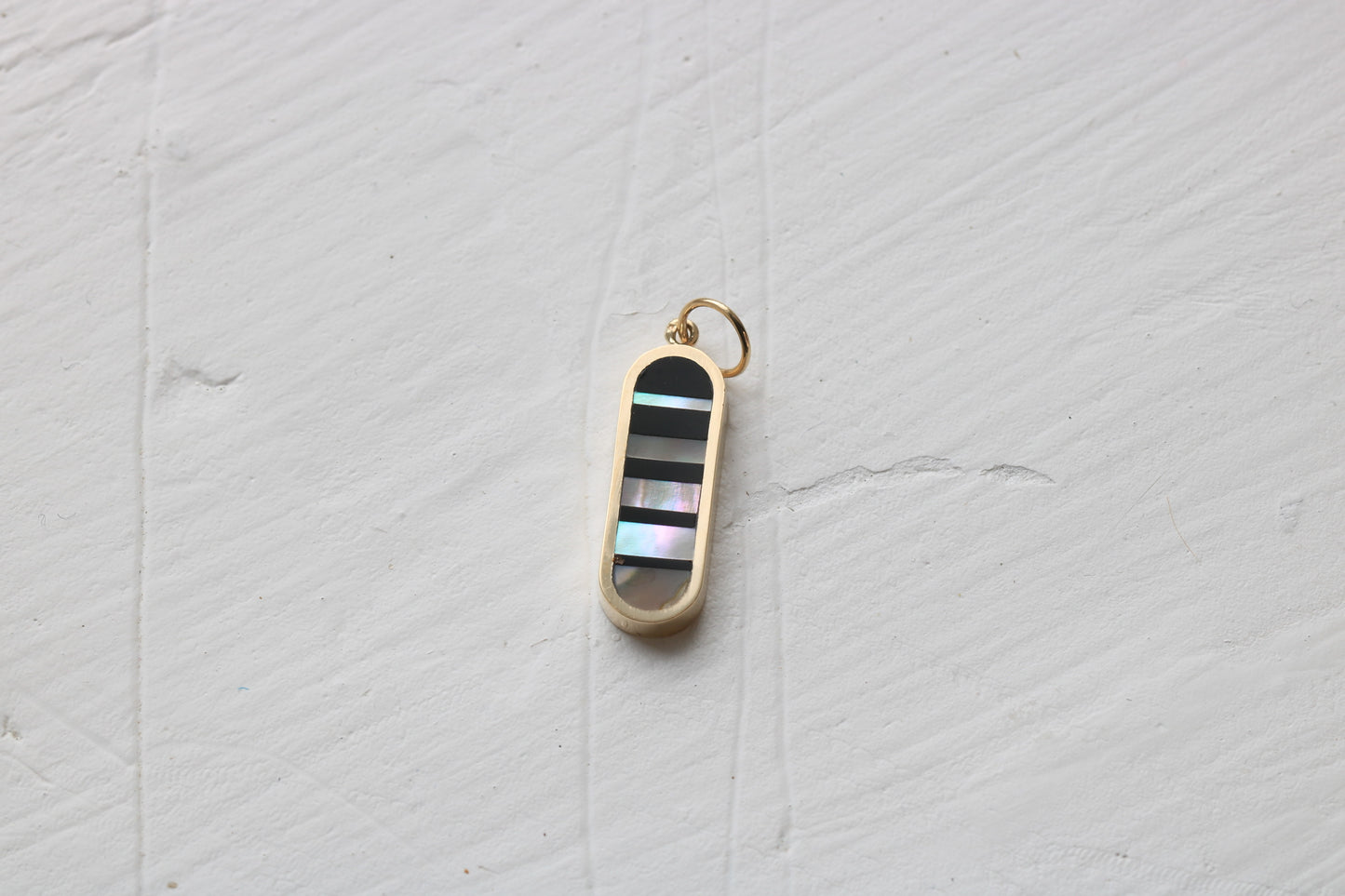 infinity charm in 14k yellow gold with black petrified wood and california red abalone inlay
