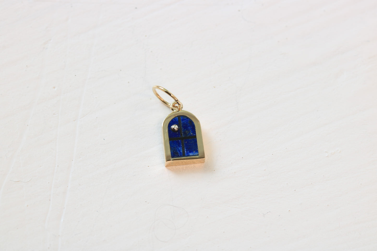 window charm in 14k gold on white background with lapis lazuli inlay