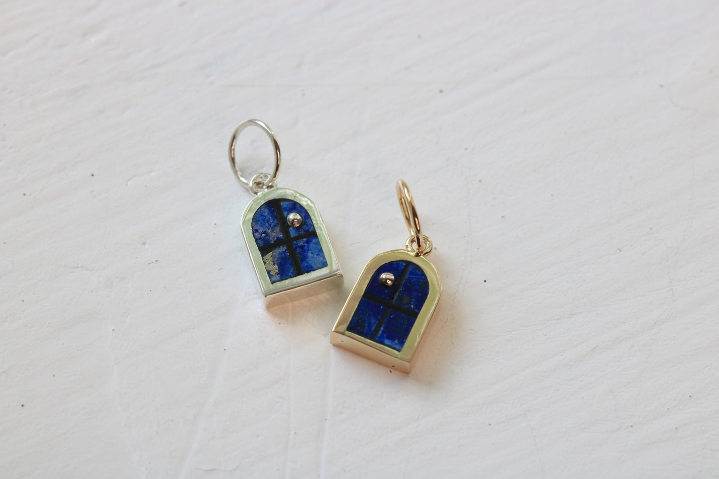 window charms in silver or 24k yellow gold with lapis lazuli inlay and sterling silver moons on white background