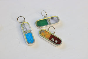 three I love drugs charms inlaid with turquoise and merlinite, chrysoprase and merlinite, or bumblebee jasper and dot's plume.  All charms are sterling silver and include xo letter descriptor.