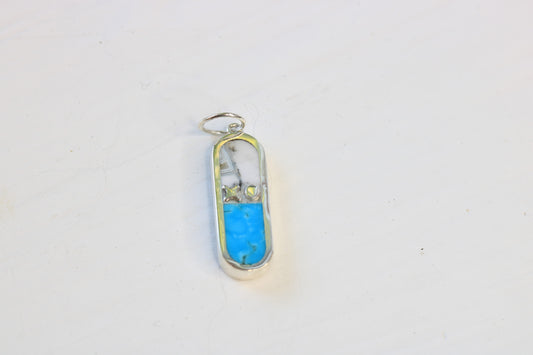 capsule shaped charm with an xo letter descriptor in sterling silver and inlaid with turquoise and merlinite on a white background