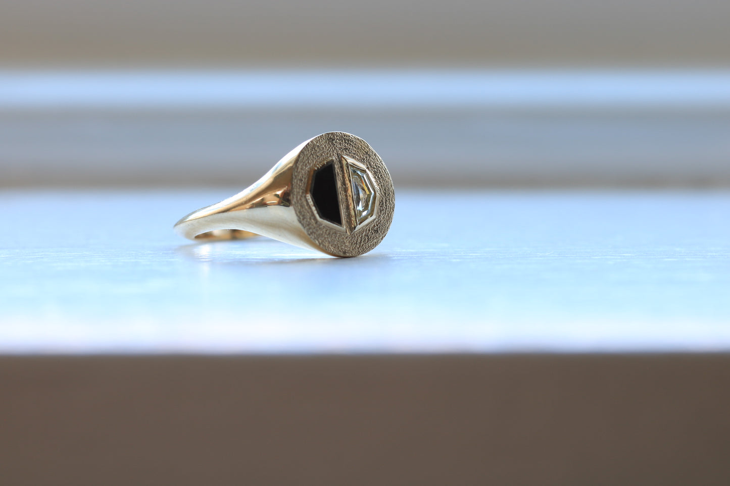 14k gold ring signet with a half octagon black stone inlay and half octagon natural diamond.