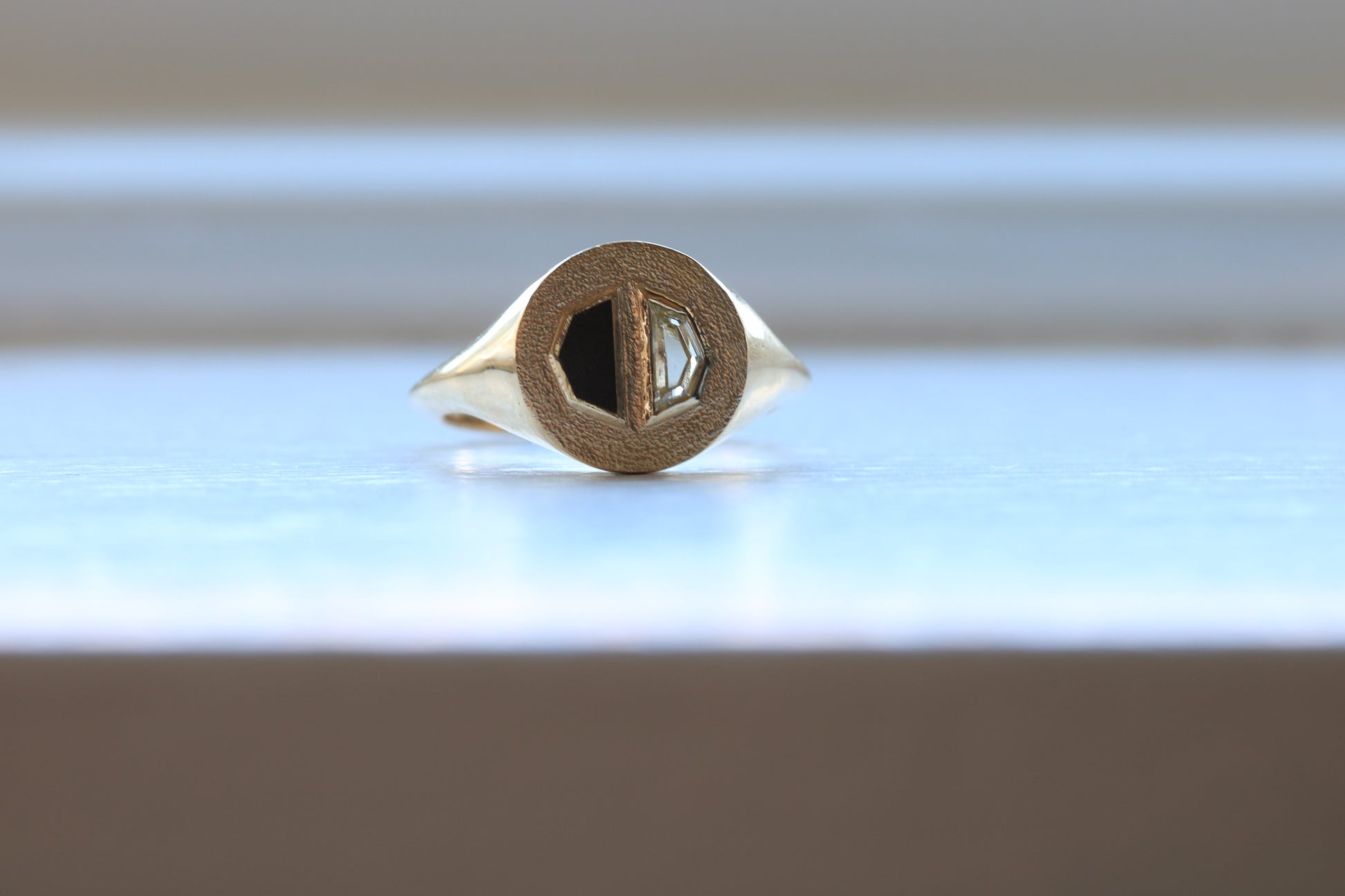 14k gold ring signet with a half octagon black stone inlay and half octagon natural diamond.