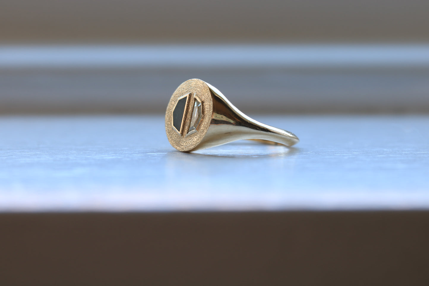 14k gold ring signet with a half octagon black stone inlay and half octagon natural diamond.