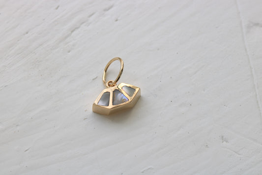 14k gold charm inlaid with abalone shell o a white background