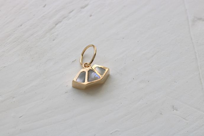 14k gold charm inlaid with abalone shell o a white background