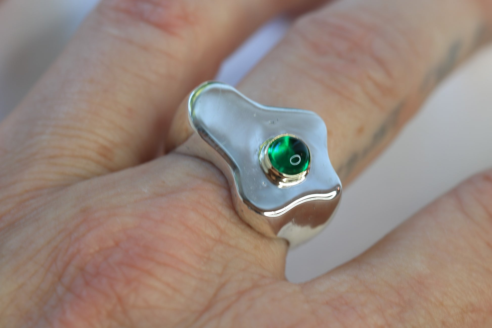 sterling silver fried egg shaped signet ring with an emerald cabochon set in 14k yellow gold.
