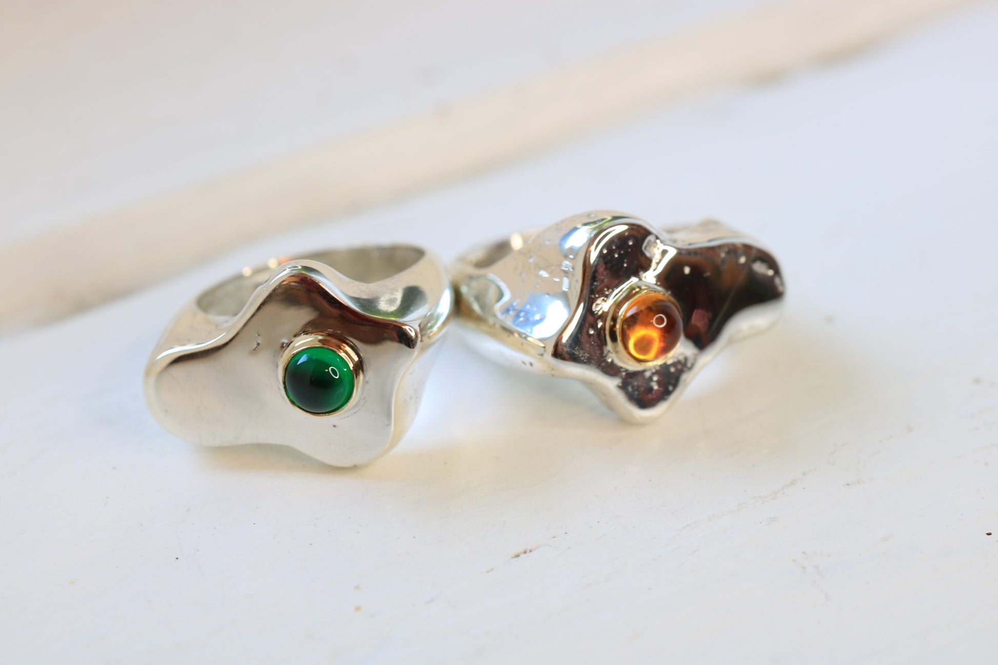 sterling silver fried egg shape sand cast rings with an emerald or citrine cabochon set in 14k gold