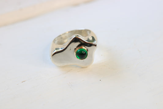 sterling silver sand cast ring in a fried egg shape with an emerald cabochon set in 14k gold