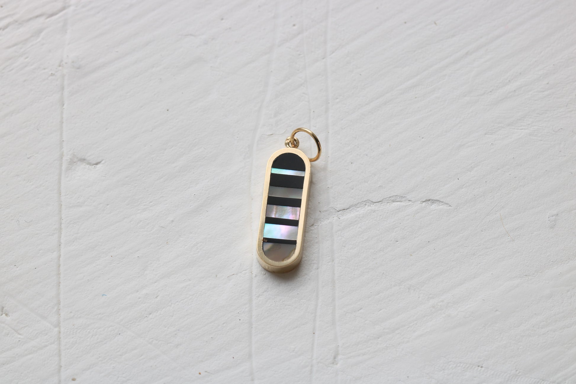 infinity charm in 14k yellow gold with black petrified wood and california red abalone inlay