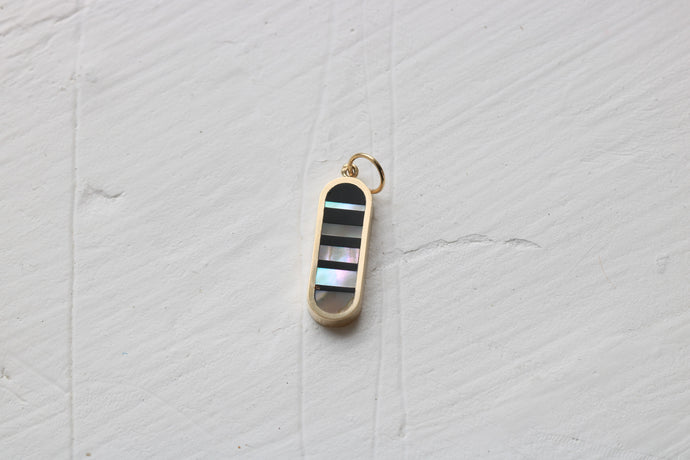 infinity charm in 14k yellow gold with black petrified wood and california red abalone inlay
