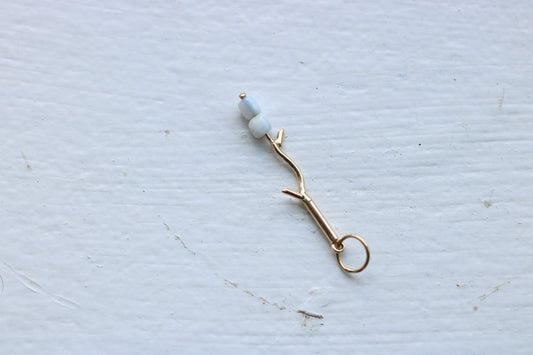 14k yellow gold branch with two mother of pearl marshmallow beads.