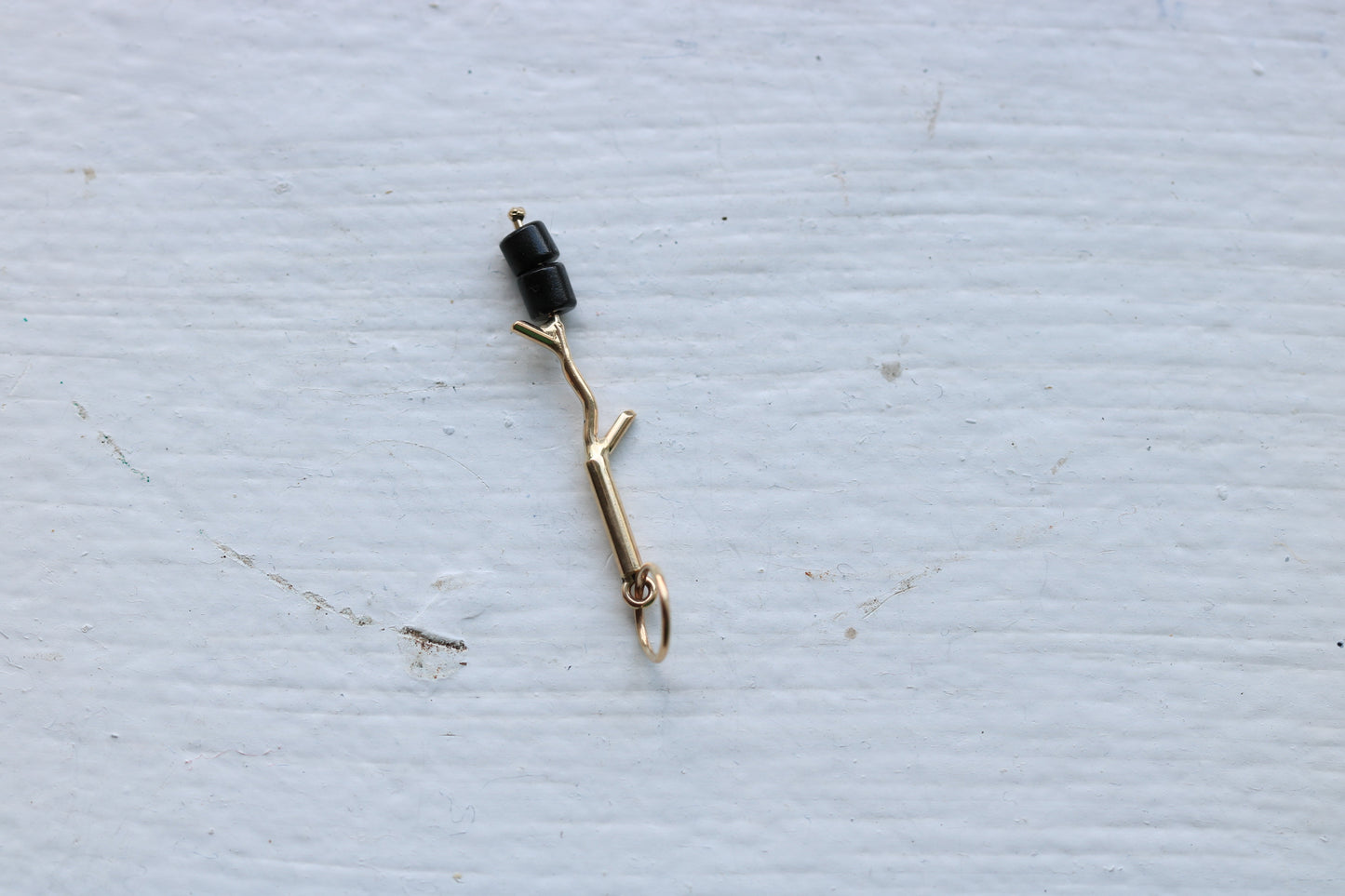 14k yellow gold branch with two onyx marshmallow beads.