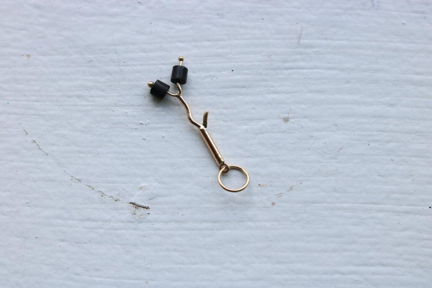14k yellow gold branch with two onyx marshmallow beads.
