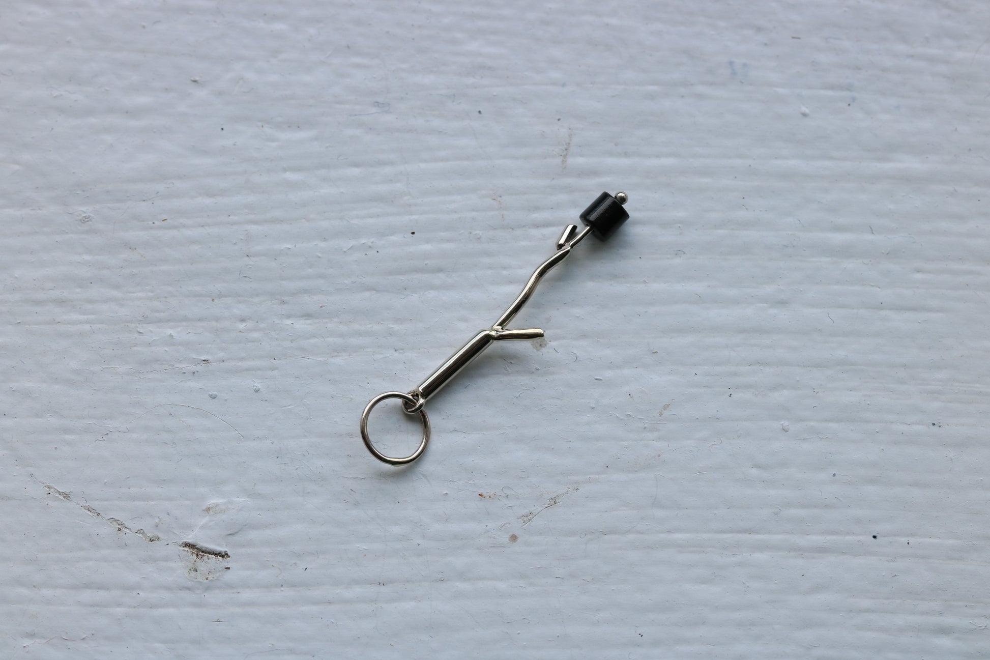 14k white gold branch with one  onyx marshmallow bead.