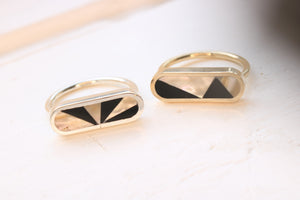 ovale abalone and black petrified wood inlaid rings in silver and in gold on white background