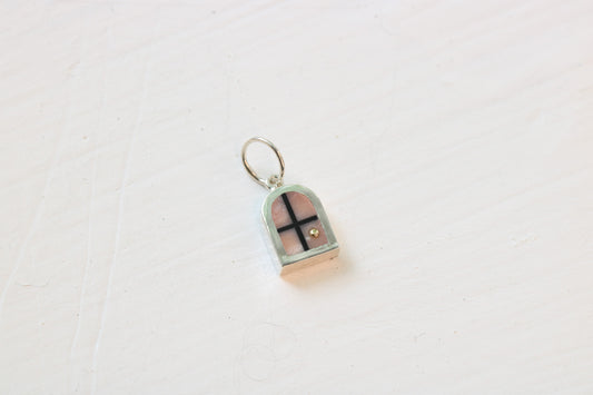 silver window charm on table with pink opal inlay and 14k gold sun