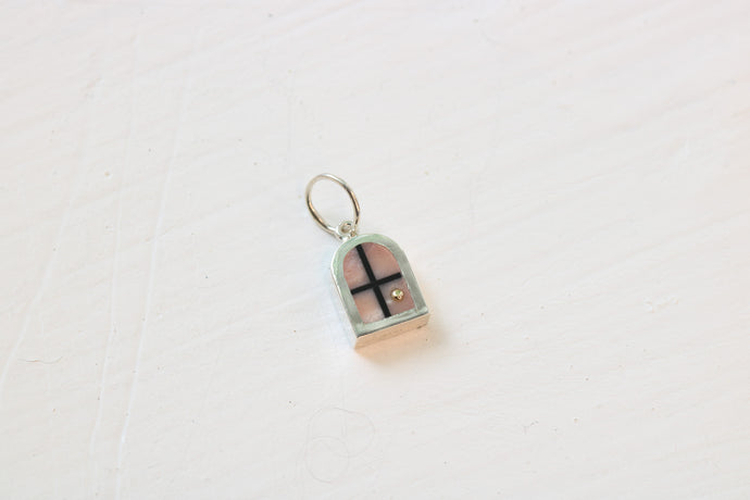 silver window charm on table with pink opal inlay and 14k gold sun