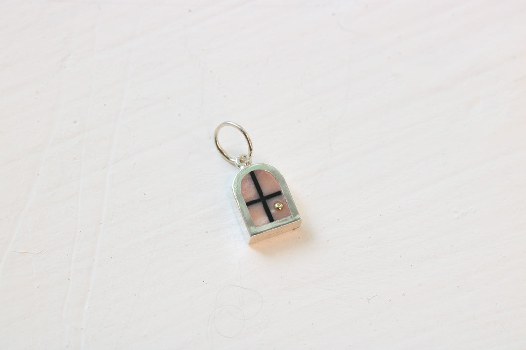 silver window charm on table with pink opal inlay and 14k gold sun