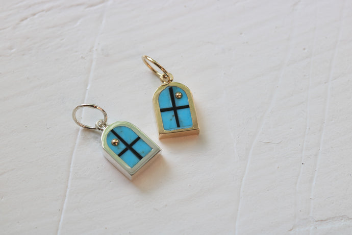 window charm in silver and gold on table with turquoise inlay and 14k gold sun